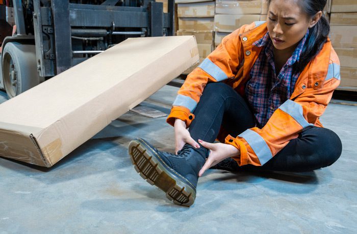 Female-worker-touching-her-ankle-after-a-fall