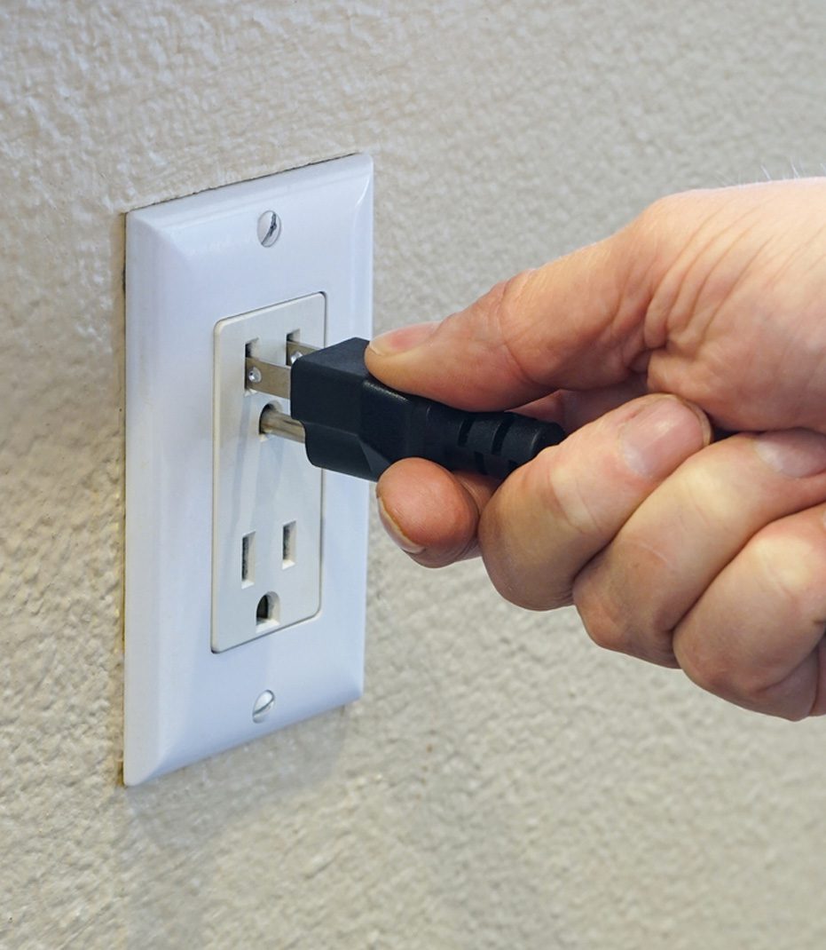 Man-plugging-cord-into-outlet