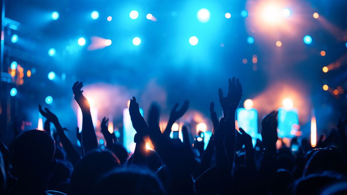 Group-of-people-dancing-with-raised-hands-at-concert