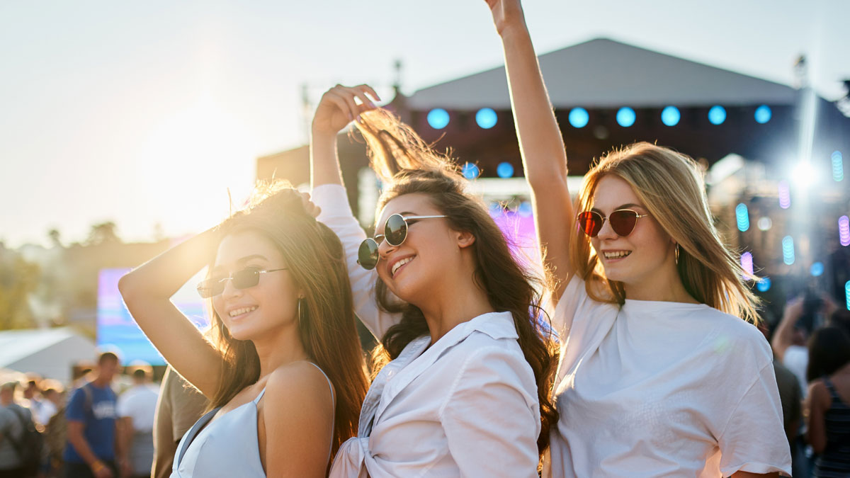 Group-of-women-dancing-at-concert-with-raised-arms