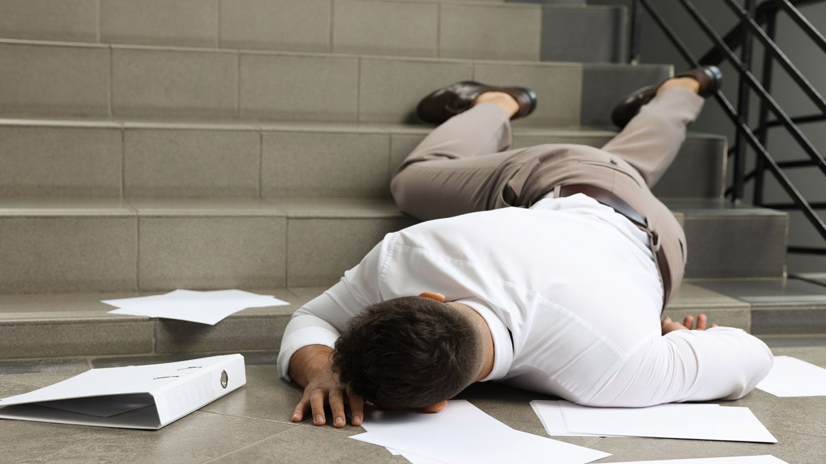 Man lying at base of stairs after fall