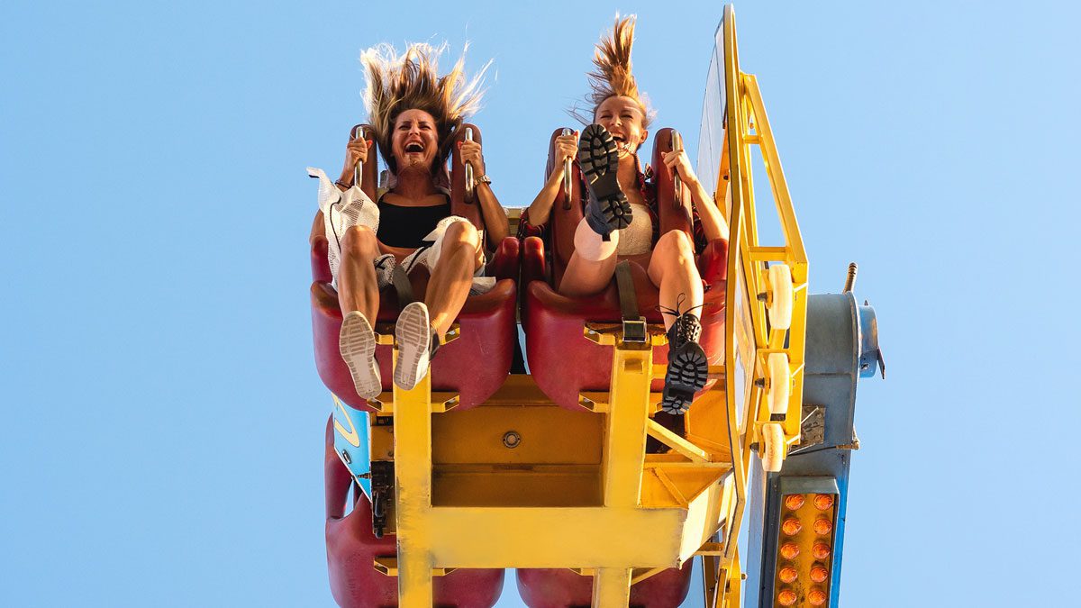 Two-women-laughing-while-riding-amusement-park-ride
