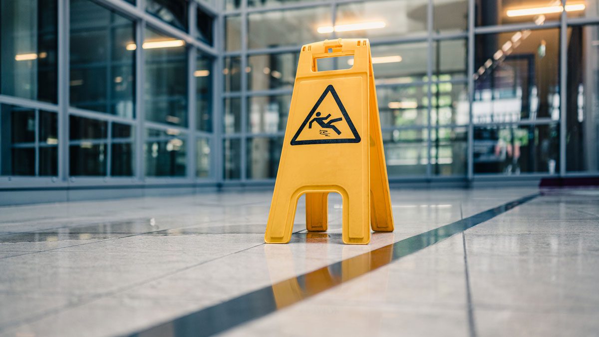 Wet floor warning sign in modern building hallway