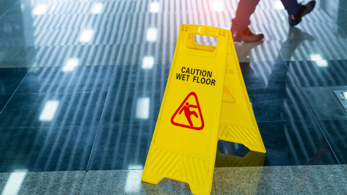 Wet floor warning sign on reflective surface