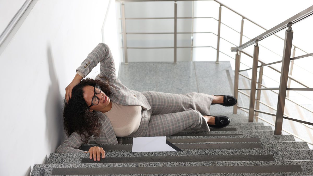 Woman-lying-on-stairs-holding-head