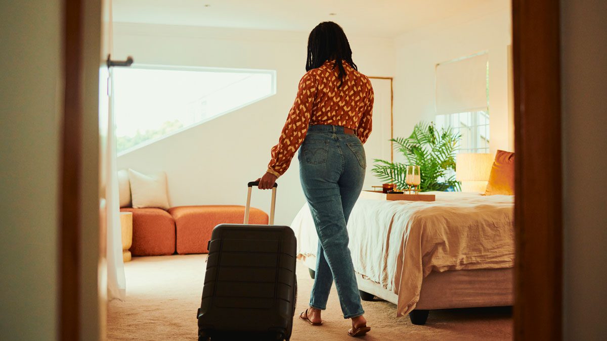 Woman-walking-into-AirBnB-with-suitcase