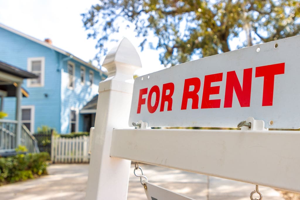 for-rent-sign-in-front-of-a-blue-house