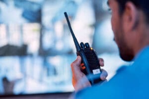 security-guard-holding-a-radio-while-watching-surveillance-monitors