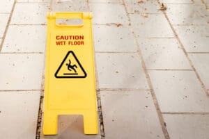 yellow-caution-wet-floor-sign-on-a-tiled-floor